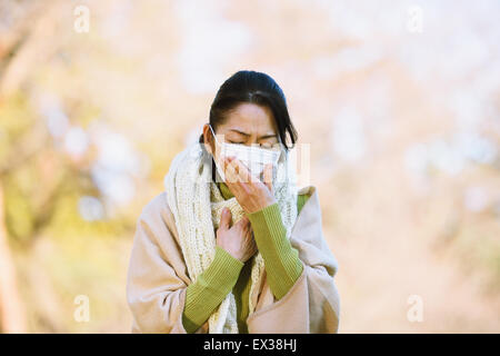 Senior donna giapponese con maschera sensazione di malessere Foto Stock