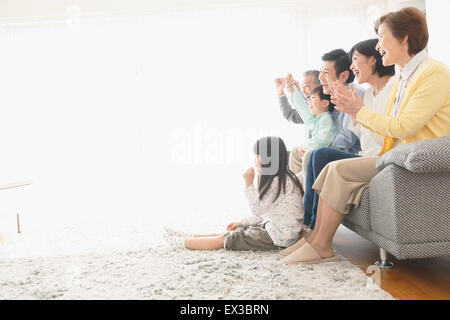 Tre generazioni di una famiglia giapponese sul divano del soggiorno Foto Stock