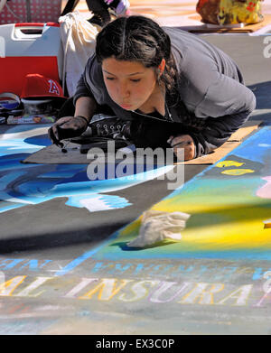 Una donna artista pittura con chalk presso la "vecchia Santa Barbara missione' durante l'I-Madonnari, street painting festival Foto Stock