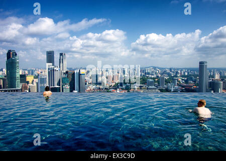 Il nuoto presso il Marina Bay Sands piscina Infinity e godendo lo skyline della città Foto Stock
