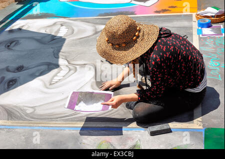 Una donna artista pittura con chalk presso la "vecchia Santa Barbara missione' durante l'I-Madonnari, street painting festival Foto Stock