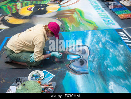 Una donna artista pittura con chalk presso la "vecchia Santa Barbara missione' durante l'I-Madonnari, street painting festival Foto Stock