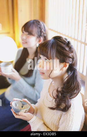 Giovani donne giapponesi godendo Maccha tè verde a Kawagoe, Giappone Foto Stock