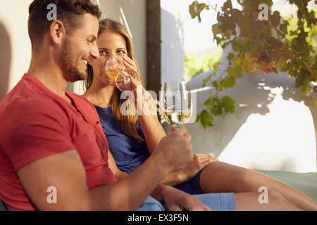 Ritratto di giovane coppia di relax all'aperto di bere vino insieme. Foto Stock