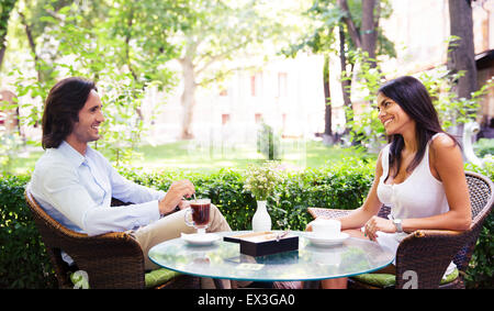 Giovane bella giovane a bere caffè e avente tempo di romantico in outdoor cafe Foto Stock