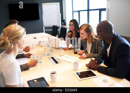 Un gruppo di giovani dirigenti tenendo una riunione in una sala conferenze Foto Stock