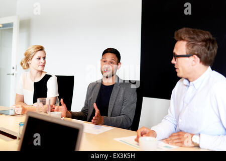 Un gruppo di giovani dirigenti avente una riunione in ufficio alla sala conferenze. Foto Stock
