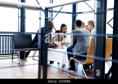 Gruppo di dirigenti seduto e lavorare insieme utilizzando compresse e il computer portatile Foto Stock