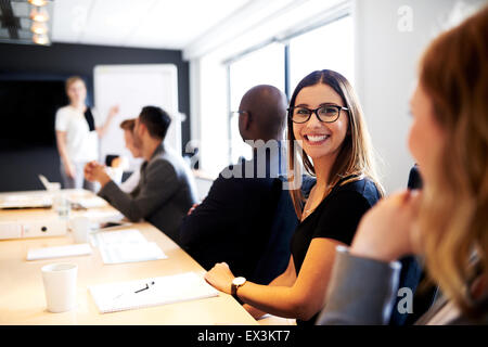 Femmina bianca executive sorridente alla telecamera durante la presentazione del lavoro in ufficio sala conferenza Foto Stock