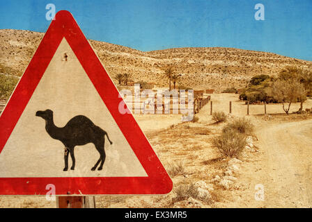 Cartello stradale - il cammello e il recinto per bestiame per i cammelli. Deserto del Negev. Foto strutturato a colore vecchio stile dell'immagine. Foto Stock