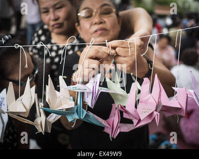 Bangkok, Bangkok, Thailandia. 6 Luglio, 2015. Persone appendere colombe di carta durante una manifestazione di protesta chiamato ''ala della pace " all Università di Thammasat/ più di un centinaio di persone si sono riuniti presso Università di Thammasat a Bangkok lunedì per mostrare il supporto per 14 studenti arrestati due settimane fa. Gli studenti sono stati arrestati per aver violato gli ordini contro il gruppo politico. Esse devono affrontare processo penale nei tribunali militari. Gli studenti' sostenitori sono mettendo su ''Post It'' note attorno a Bangkok e campus universitari fino paese richiamando per studenti di rilascio. Credit: Jack Kurtz/ZUMA filo/Alamy Live News Foto Stock