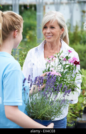 La donna chiede il personale per pianta la consulenza al Centro giardino Foto Stock