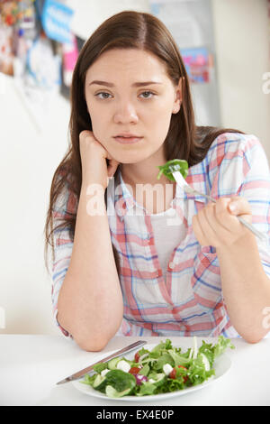 Ragazza adolescente sulla dieta mangiare piatto di insalata Foto Stock