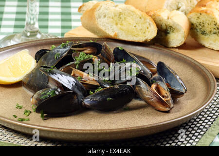 Frutti di mare cozze in salsa di vino bianco con prezzemolo e aglio pane Foto Stock