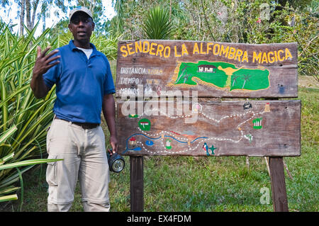 Ritratto orizzontale di una guida turistica di fronte una scheda di informazioni in Topes de Collantes Parco Nazionale di Cuba. Foto Stock