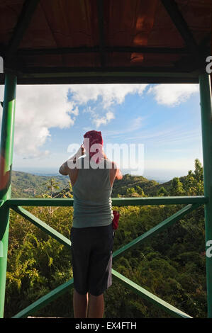 Vista verticale di un turista di scattare le foto da un posto di vedetta in Topes de Collantes Parco Nazionale di Cuba. Foto Stock