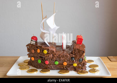 Pirate Torta al cioccolato su una piastra bianca. Con le monete di cioccolato. Foto Stock