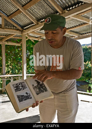 Ritratto verticale di un tour leader che mostra i turisti un libro su Fidel Castro Turquino nel Parco Nazionale di Cuba. Foto Stock