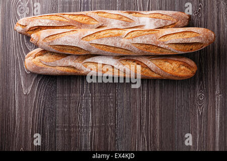 Tre fresca baguette francese sul grigio Sfondo di legno Foto Stock