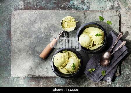 Il tè verde gelato con foglie di menta e cucchiaio per gelato su pietra ardesia sfondo Foto Stock