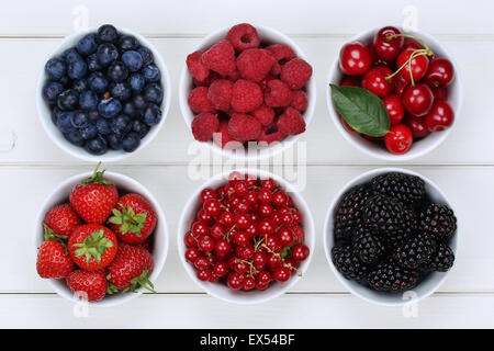 Bacche in ciotole con fragole, mirtilli e ribes rossi, ciliegie, lamponi e more Foto Stock