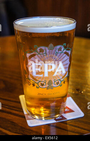 Una pinta di Marston's EPA real ale su un pub beermat tabella bicchieri di bevande Foto Stock