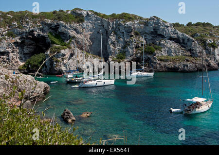 Sailing yacht ormeggiati in una appartata baia rocciosa di Calas insenature dell'isola di Minorca spagna Foto Stock