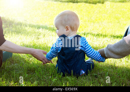 Bambino con la madre e il padre tenendo le mani Foto Stock