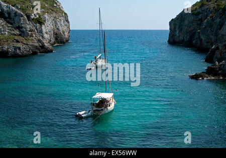 Due barche a vela ormeggiata in appartata baia rocciosa di Calas insenature dell'isola di Minorca spagna Foto Stock