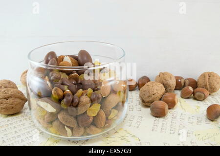 Snack mix di noci, uva passa,nocciole, mandorle e cioccolata in tazza su un decoupage decorata tabella Foto Stock