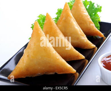 Carni bovine Samosa nel piatto nero Foto Stock