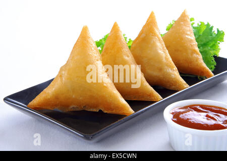 Carni bovine Samosa nel piatto nero Foto Stock