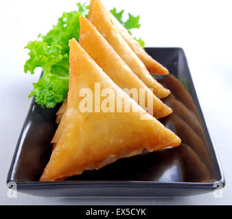 Carni bovine Samosa nel piatto nero Foto Stock