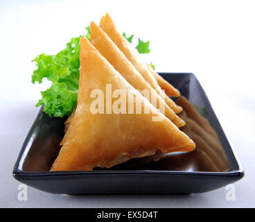 Carni bovine Samosa nel piatto nero Foto Stock