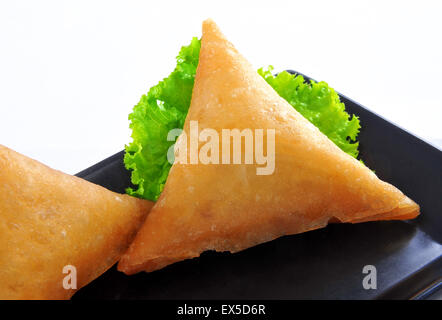 Carni bovine Samosa nel piatto nero Foto Stock