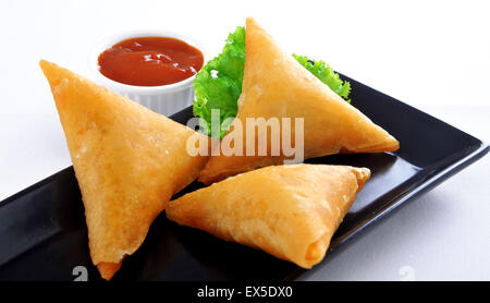 Carni bovine Samosa nel piatto nero Foto Stock