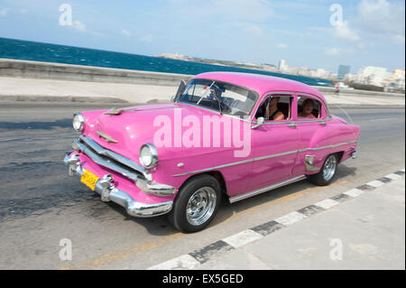 L'Avana, Cuba - 18 Maggio 2011: Rosa Classic American taxi trascina lungo la strada sul lungomare di El Malecon nel centro di Avana. Foto Stock