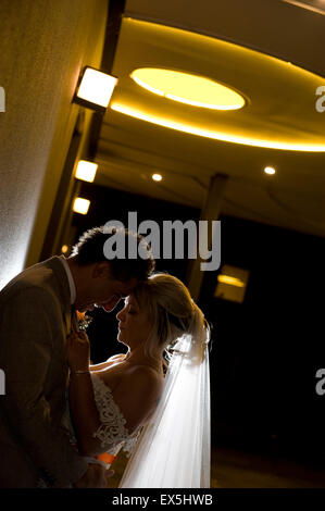 Profili della sposa e lo sposo affacciati, retroilluminati di notte Foto Stock