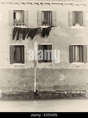 Il lavaggio appeso sopra un canale esterno di una casa tradizionale Murano Laguna di Venezia Veneto Italia Europa Foto Stock