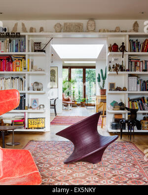 Round chair di Thomas Heatherwick in sala da disegno con incorporato di libro scaffali e tappeti marocchini. Il teste scolpite sono da Eduard Foto Stock