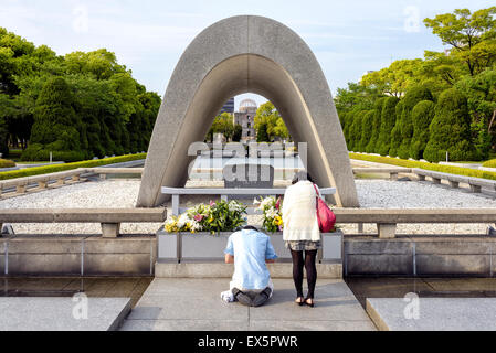 Hiroshima, Giappone - 27 Aprile 2014: vista di una giovane giapponese in preghiera di fronte il Cenotafio nel Parco della Pace. Foto Stock