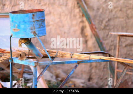 Dipinto di blu strano dispositivo metallico con vaso di vernice e il tubo.cantiere di fronte casa città nella zona inferiore della città-Gyantse-Tibet. Foto Stock