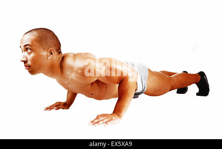 Un giovane giamaicano bodybuilder sdraiato sul pavimento facendo il suo punch-up per sfondo bianco e guardando dritto. Foto Stock