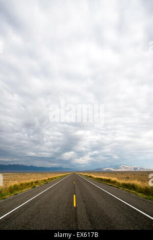 Svuotare strada aperta con cielo nuvoloso fotografati da un angolo basso con un grandangolo Foto Stock