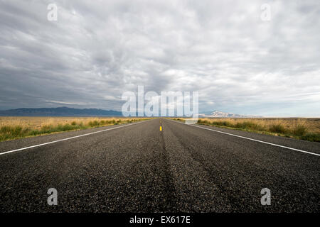 Svuotare strada aperta con cielo nuvoloso fotografati da un angolo basso con un grandangolo Foto Stock