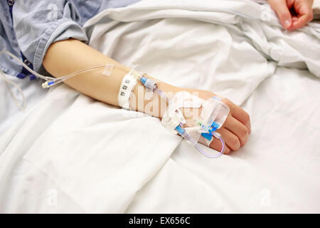Paziente con IV linee giacendo nel letto di ospedale Foto Stock