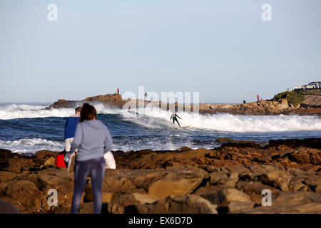 Acqua fredda in inverno il surf sulla costa rocciosa in Mossel Bay, Sud Africa Foto Stock