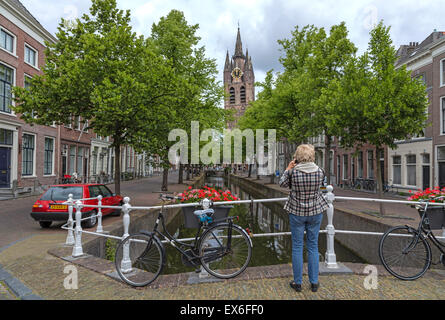 Una donna di scattare una foto della vecchia chiesa ( Oude Kerk ) in Delft, risalente al 1246, South Holland, Paesi Bassi. Foto Stock