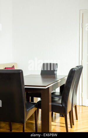 Sala da pranzo interno con tavolo e quattro sedie nere vicino alla cucina. Area colazione spot. Lo spazio di lavoro e riunioni aziendali wi Foto Stock