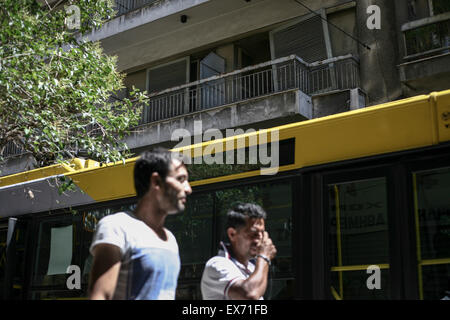 Persone che passano da una posizione chiusa e hotel abbandonato a Atene, Grecia del 8 luglio 2015. La zona euro è bailout, il Fondo europeo di meccanismo di stabilità (ESM), ha detto che ha ricevuto una richiesta da parte della Grecia di un nuovo pacchetto di aiuti. Foto: Socrates Baltagiannis/dpa Foto Stock